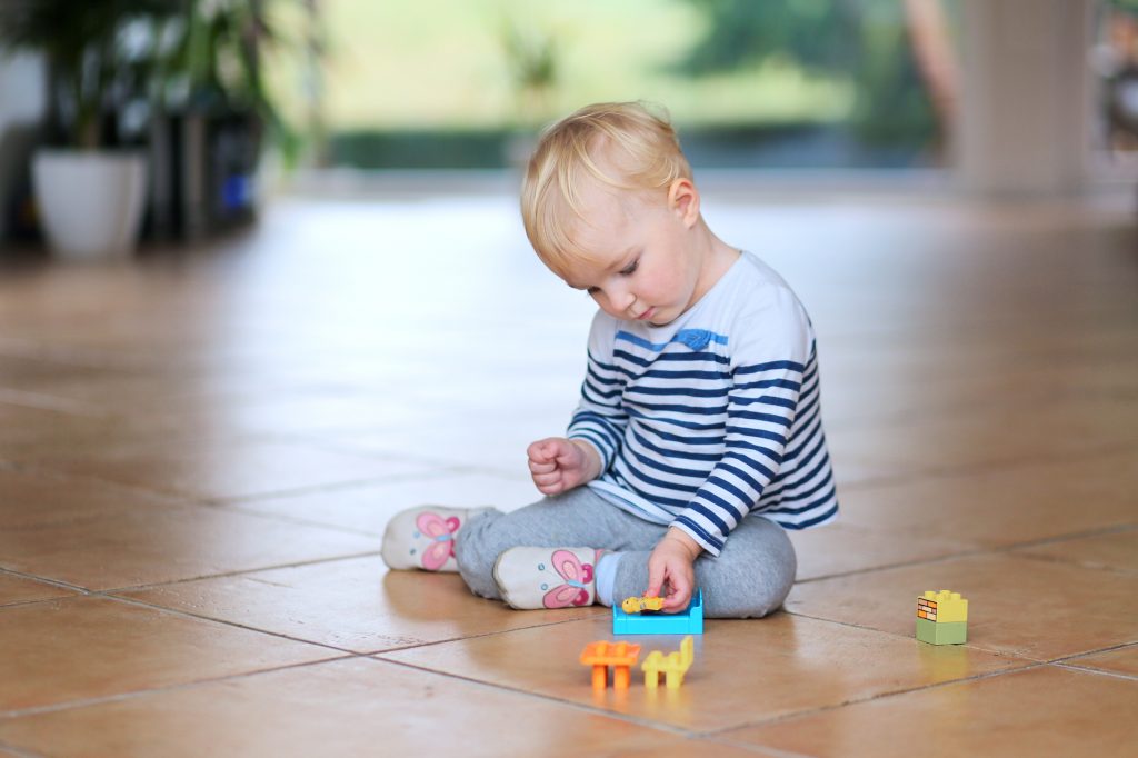 kid playing on clean tile floor