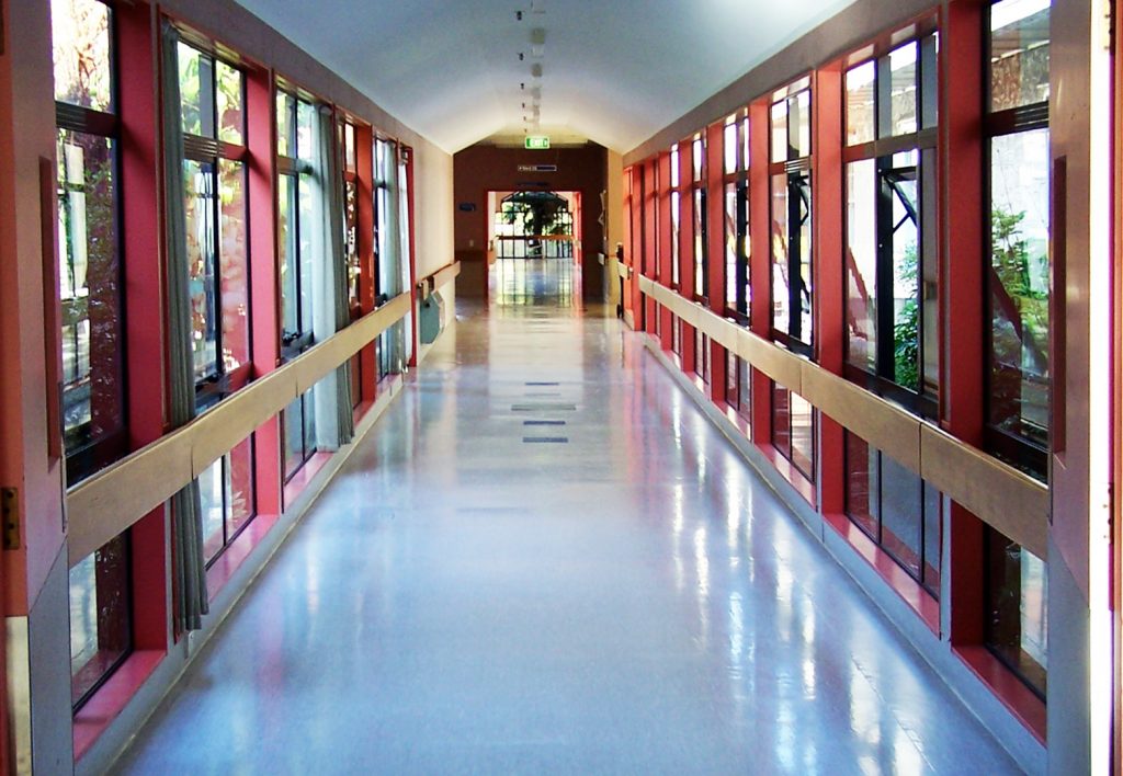 VCT floors in hospitals like this one require regular cleaning not only for the safety of visitors, but also for the health of patients. This white floor has recently been cleaned and is bordered by tan wooden handrails accented by deep red window borders. Hospitals and medical centers in Radford, Blacksburg, Roanoke and beyond should contact Quest Floor Care.